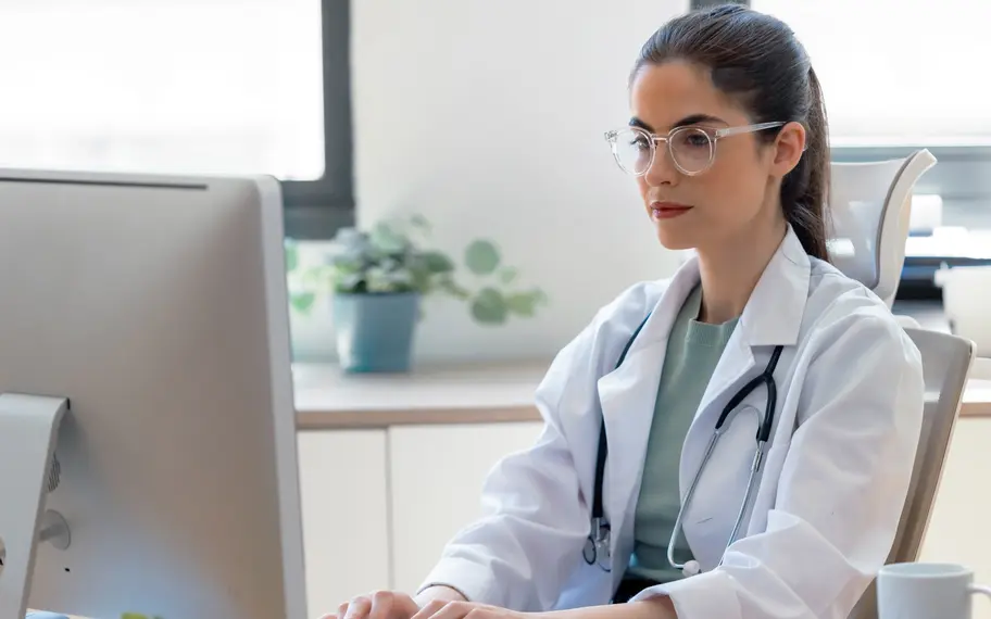 Das Bild zeigt eine Ärztin, die eine Nachricht am Computer verfasst.