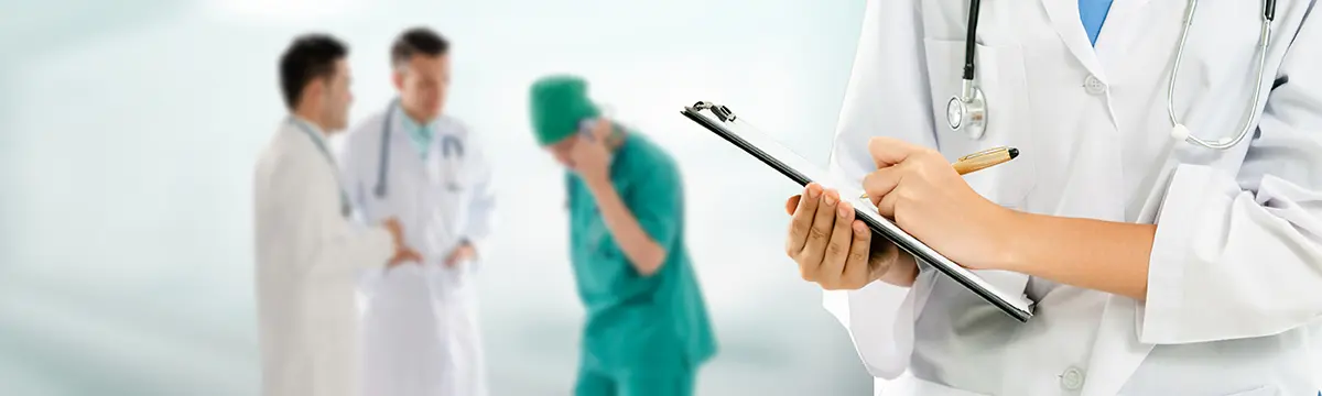 Medizinisches Team, im Vordergrund Ärztin, die etwas notiert (Symbolbild)