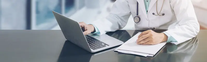 Arzt arbeitet am Schreibtisch mit Computer Arzt arbeitet am Schreibtisch mit Computer (Symbolbild)