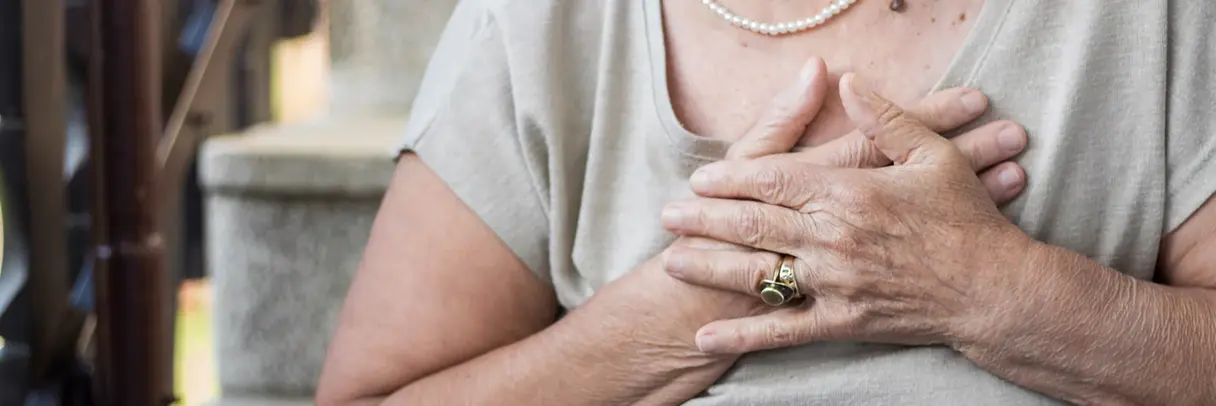 Das Bild zeigt eine Frau, die ihre Hände auf ihr Herz hält. Es handelt sich um ein Symbolbild für Herzinsuffizienz.