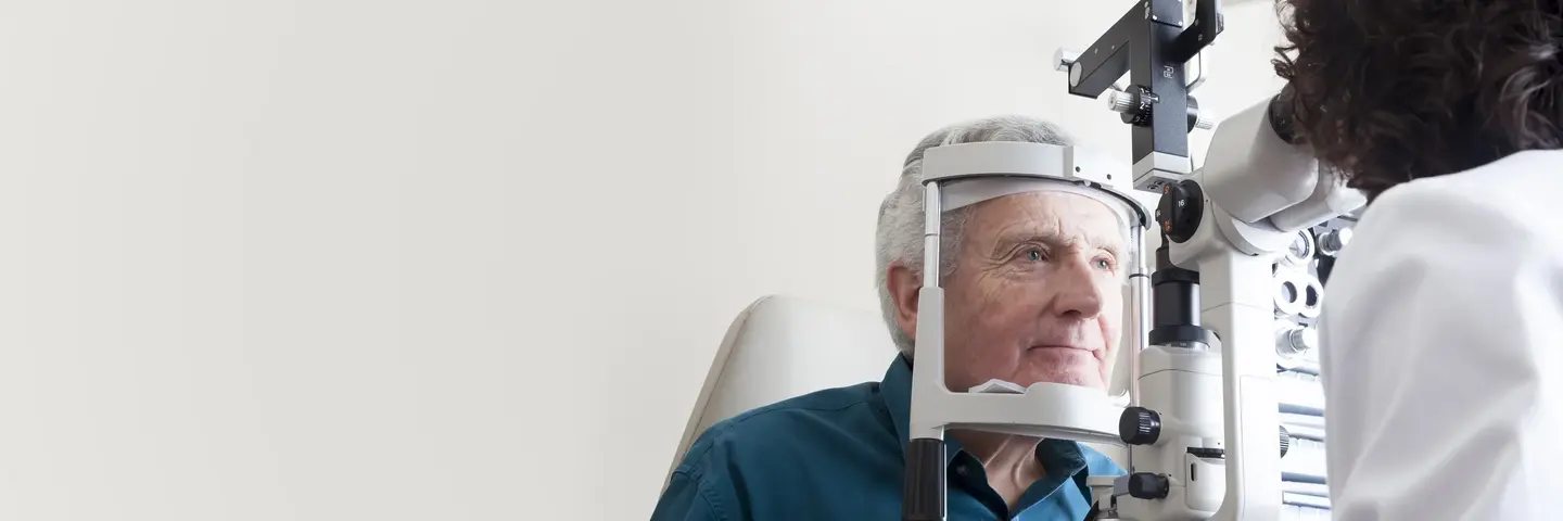 Augenoptiker untersucht älteren Patienten.