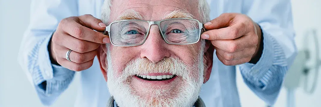 Optiker passt älterem Mann eine Brille an