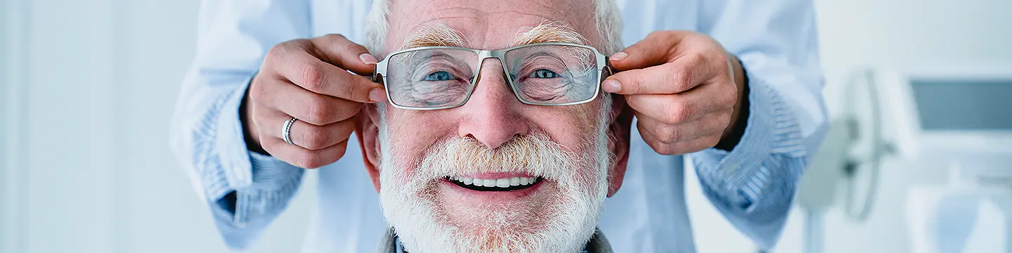 Optiker passt älterem Mann eine Brille an