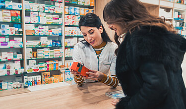 Apothekerin und Kundin lesen die Aufschrift auf Medikamenten-Verpackung (Symbolbild)