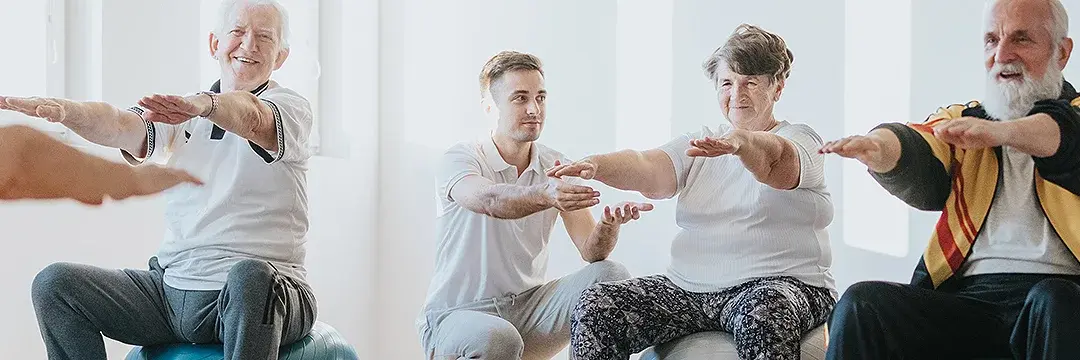 Senioren bei Ballgymnastik Senioren bei Übungen auf blauen Gymnastikbällen