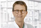 Porträt von Professor Heribert Schunkert mit Brille und weißem Kittel.