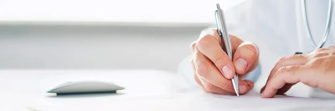 Arzt schreibt eine Verordnung oder Rezept Arzt hält einen Stift in der Hand und schreibt eine Verordung oder Rezept