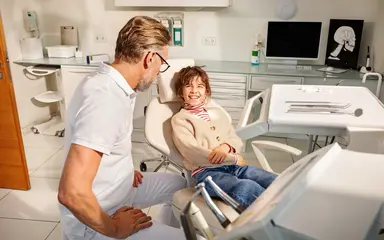 Patientin lächelt Zahnarzt an