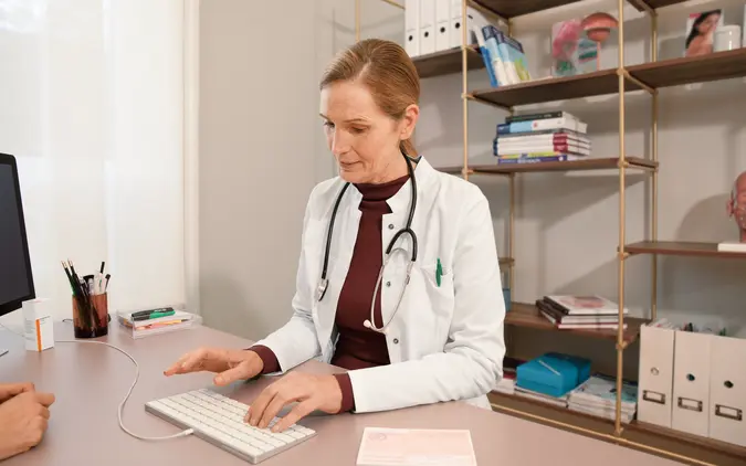 Ärztin arbeitet an Schreibtisch Ärztin arbeitet an Schreibtisch