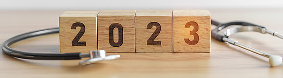 Jahreswechsel 2023: Foto zeigt Kalender und Stethoskop auf einem Tisch