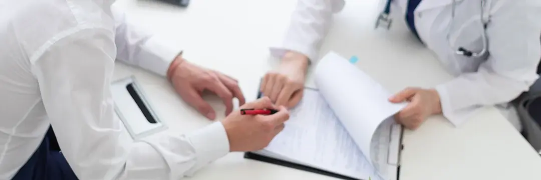 Patient in Arztpraxis unterschreibt Dokumente Patient in Arztpraxis unterschreibt Dokumente (Symbolbild)