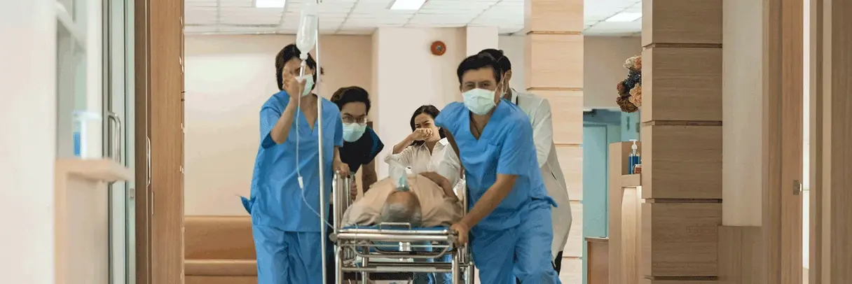 Foto: Klinikteam schiebt einen Notfallpatienten durch den Krankenhausflur