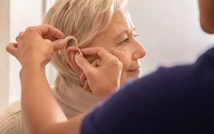 Frau bekommt Hörgerät eingesetzt