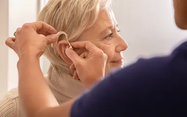 Frau bekommt Hörgerät eingesetzt