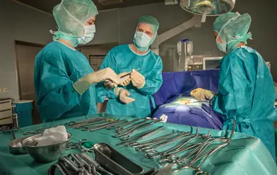 Chirurgie: Ärztinnen und Ärzte in OP-Kleidung operieren einen Patienten. Chirurgisches Team im OP