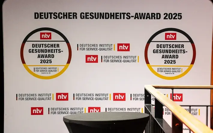 Hintergrundbanner für den Deutschen Gesundheits-Award 2025 mit den Logos von ntv und dem Deutschen Institut für Service-Qualität. Zwei große Kreise mit dem Text 'DEUTSCHER GESUNDHEITS-AWARD 2025'.