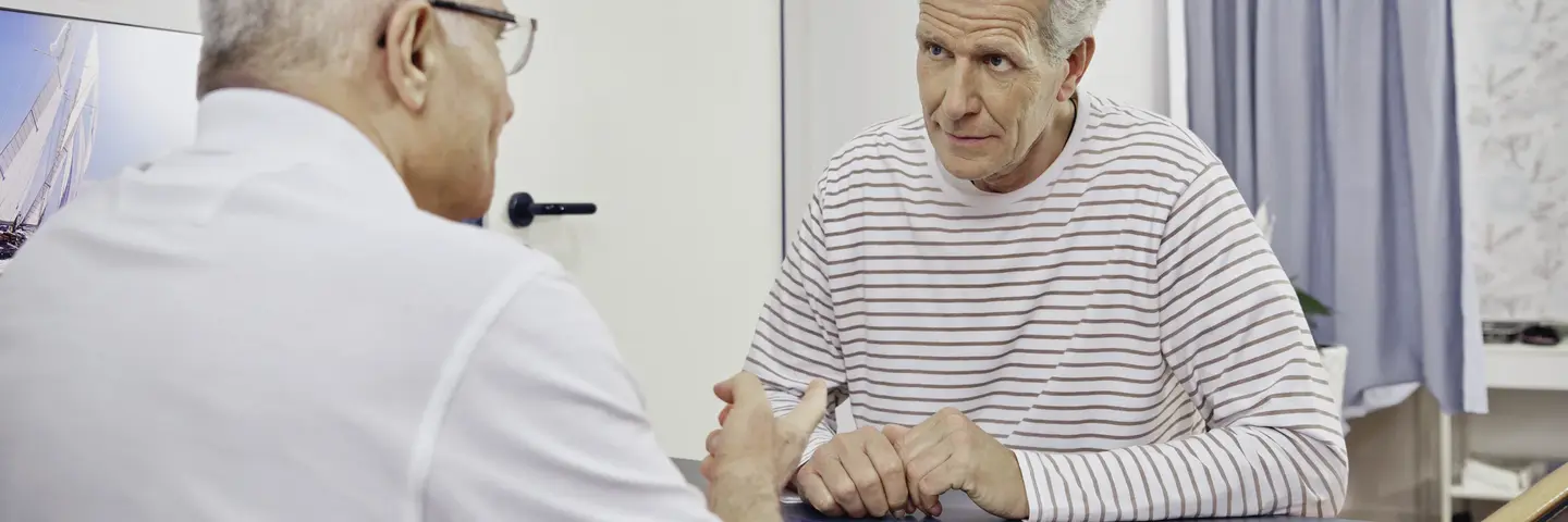 Arzt im Gespräch mit älterem Patienten