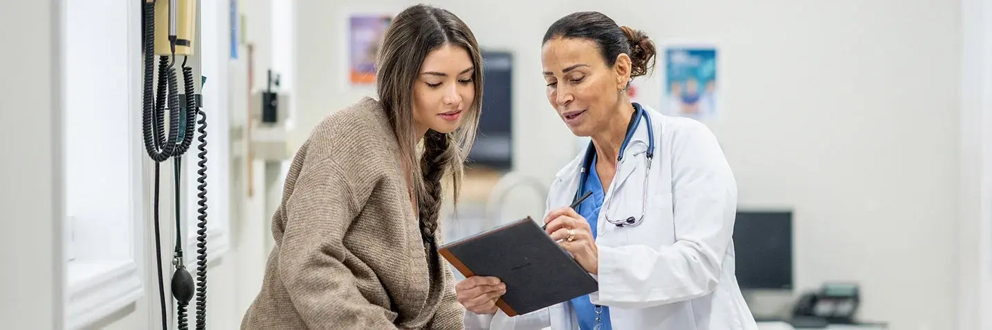 Shared Descision Making: Ärztin im Gespräch mit Patientin Ärztin erklärt einer Patientin in der Praxis gemeinsam eine Entscheidung anhand eines Tablets