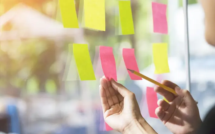 Post-Its an Glaswand: Symbol für innovative Projekte