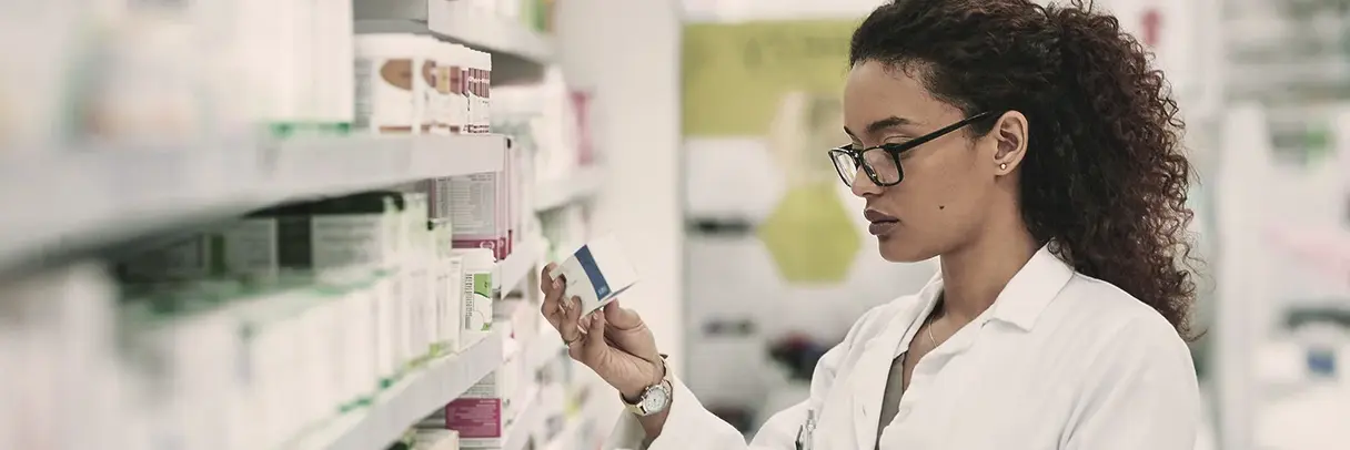 Apothekerin liest Medikamentenverpackung