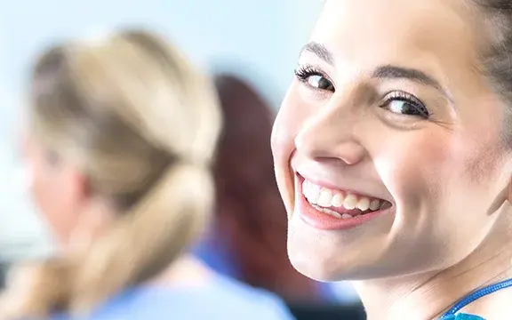 Junge Pflegekraft lächelt im Vordergrund