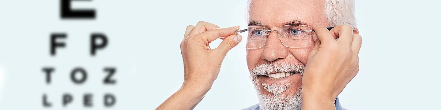 Optiker setzt älterem Mann neue Brille auf