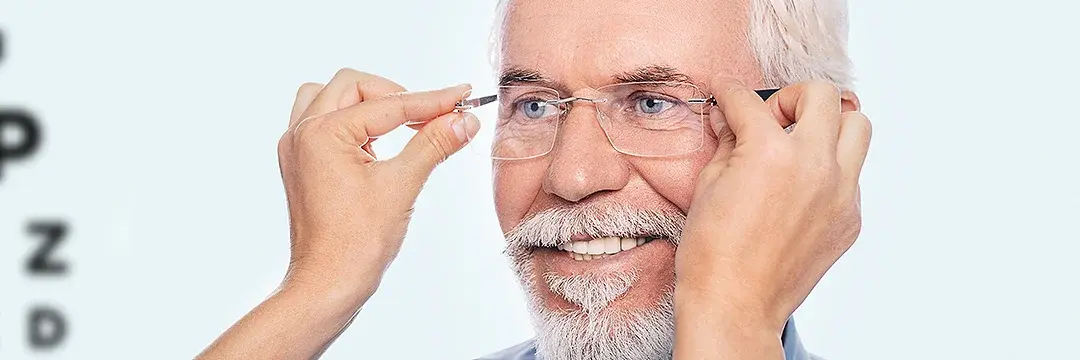 Optiker setzt älterem Mann neue Brille auf