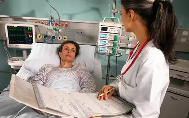 Patientin auf der Intensivstation im Gespräch mit einer Ärztin. Foto: Patientenvisite