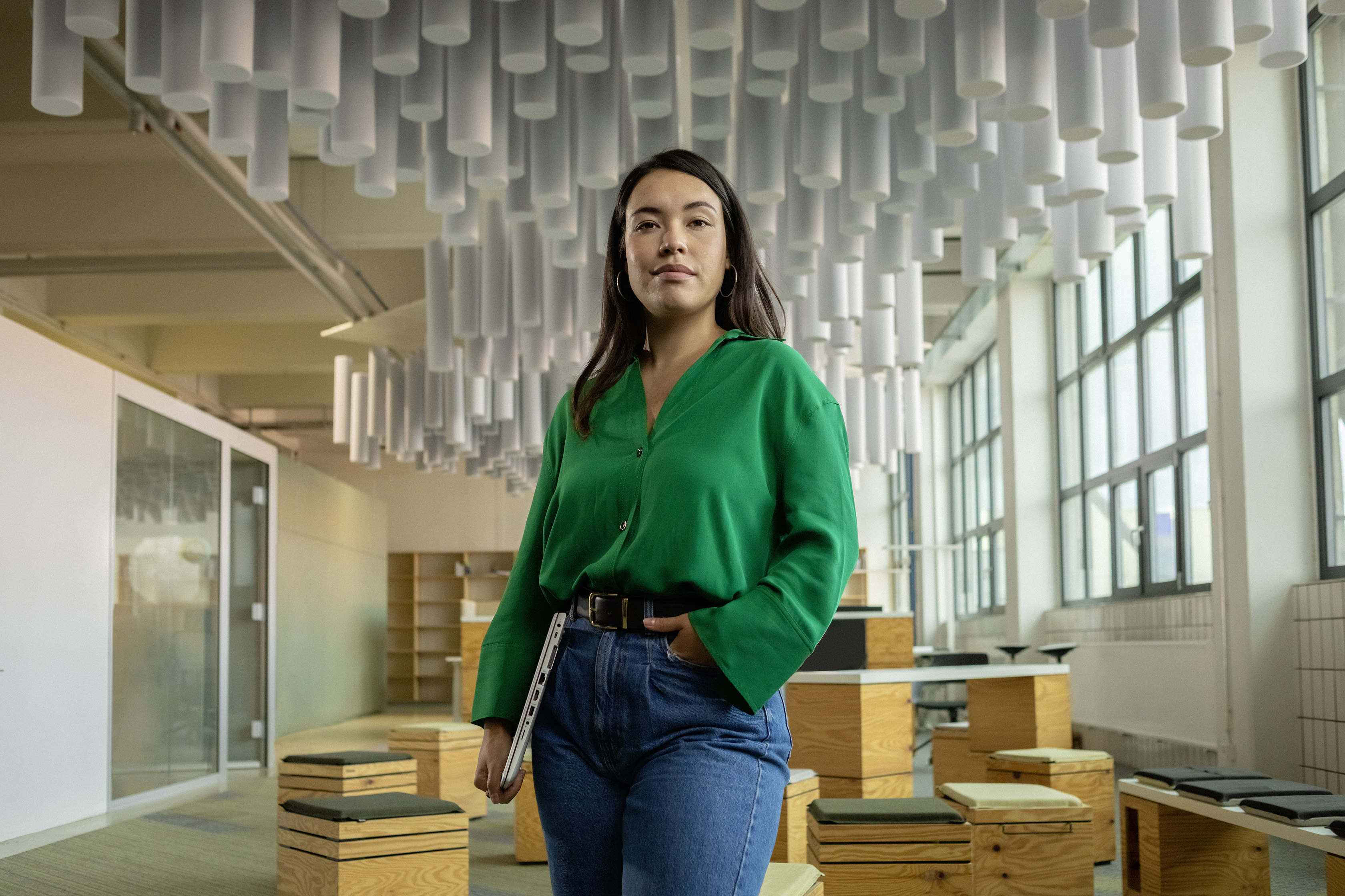 Eine junge Berufserfahrene steht in einem Raum vor Umzugskisten.