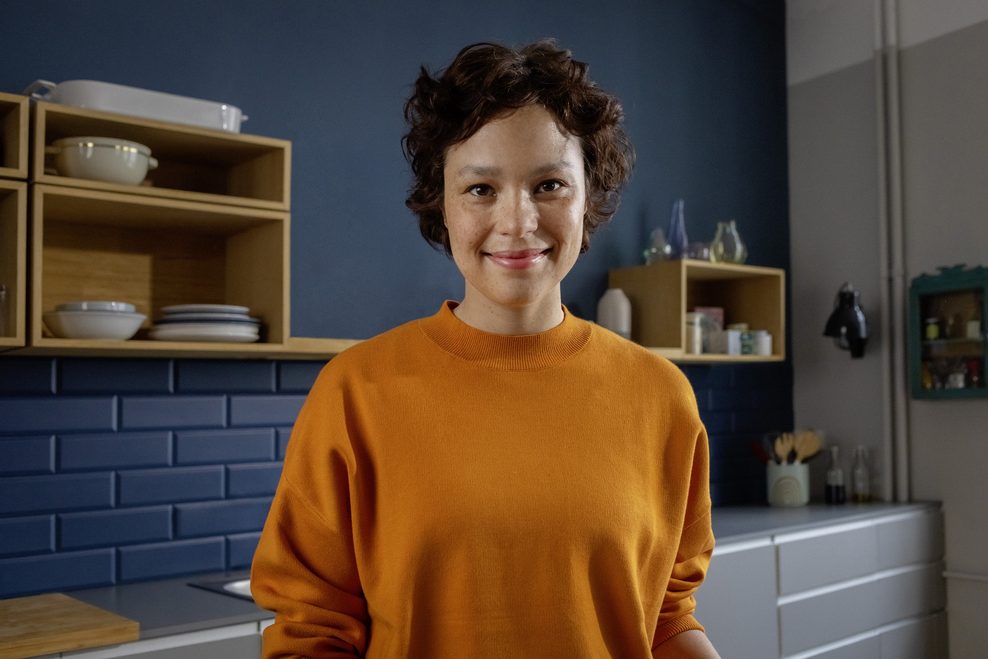 Eine berufserfahrene Frau steht in ihrer Küche.