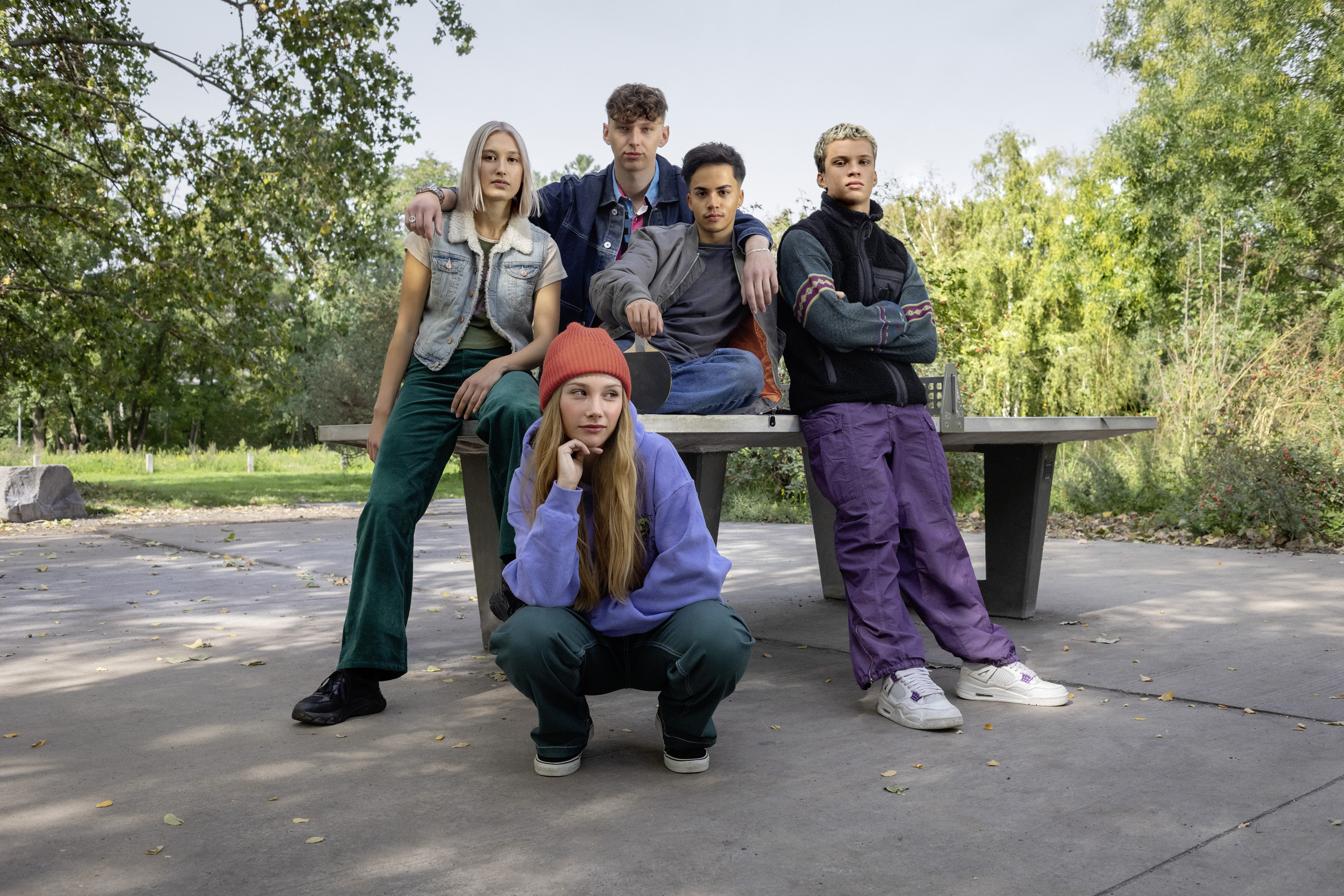 Eine Clique von Schülerinnen und Schülern posiert an einer Tischtennisplatte.