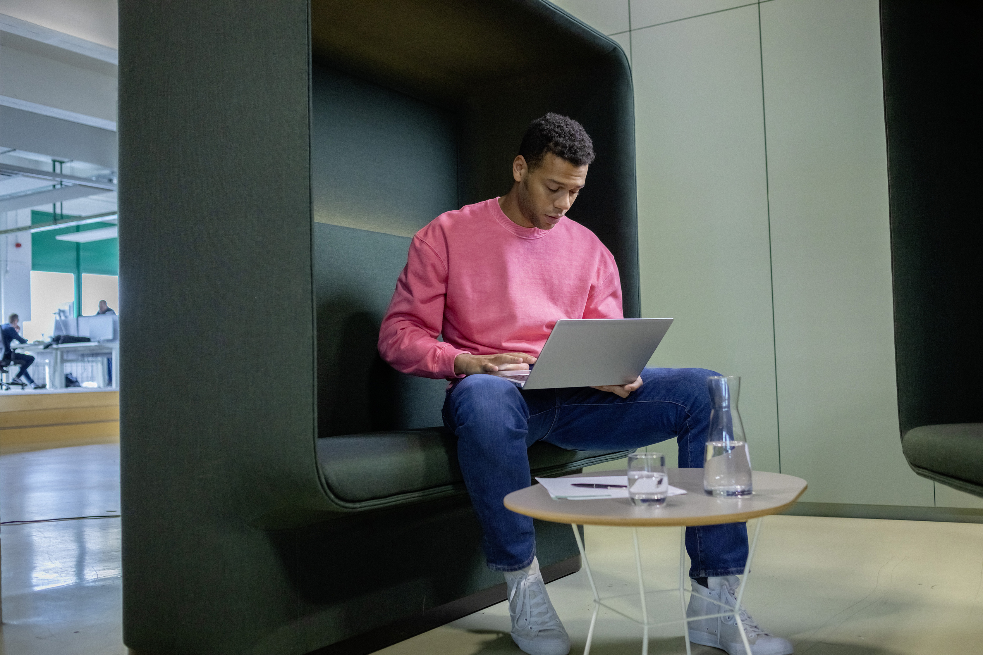 Ein berufserfahrener Mann sitzt mit Laptop in einem Besprechungsraum.