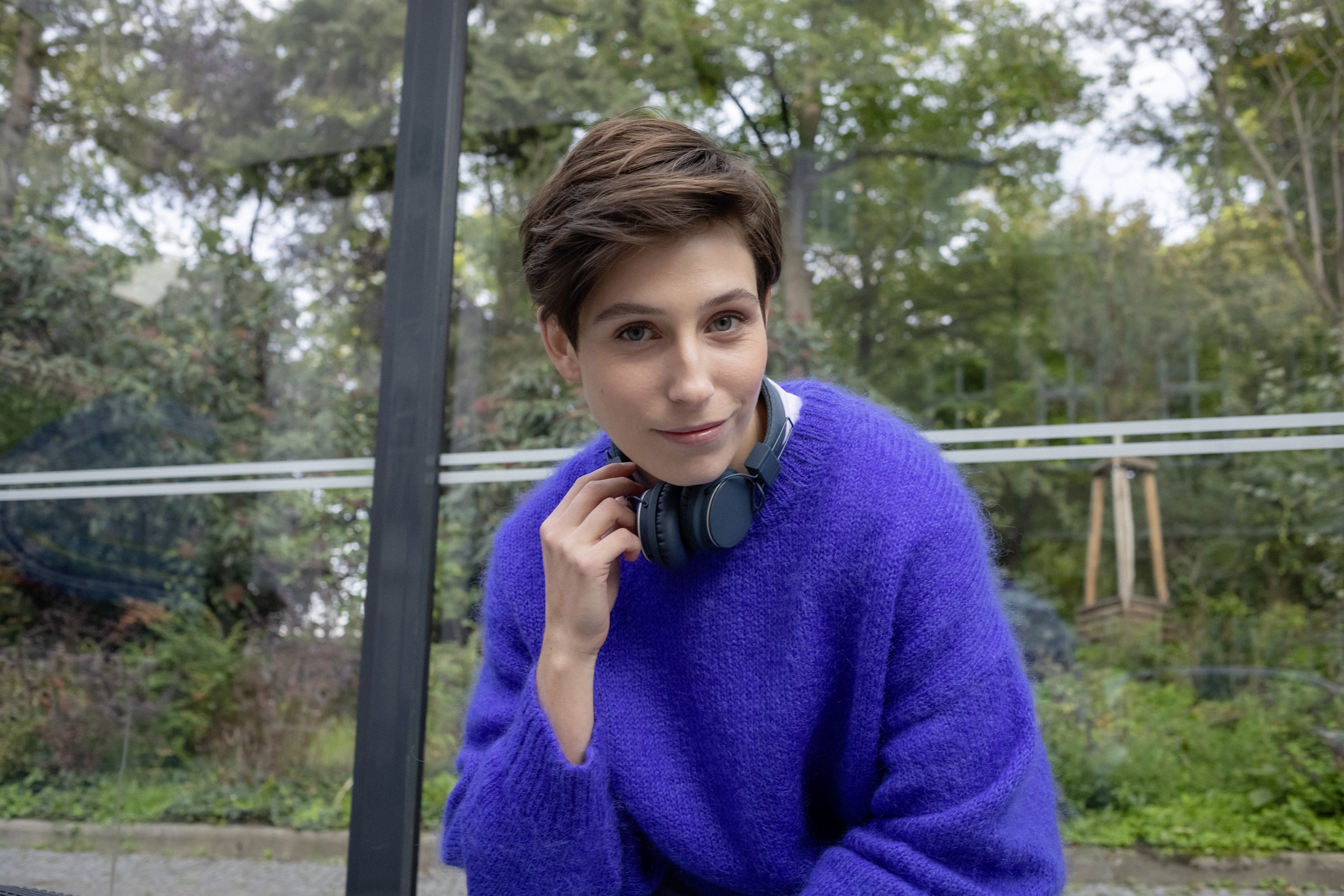 Eine Studentin sitzt in einer Bushaltestelle.