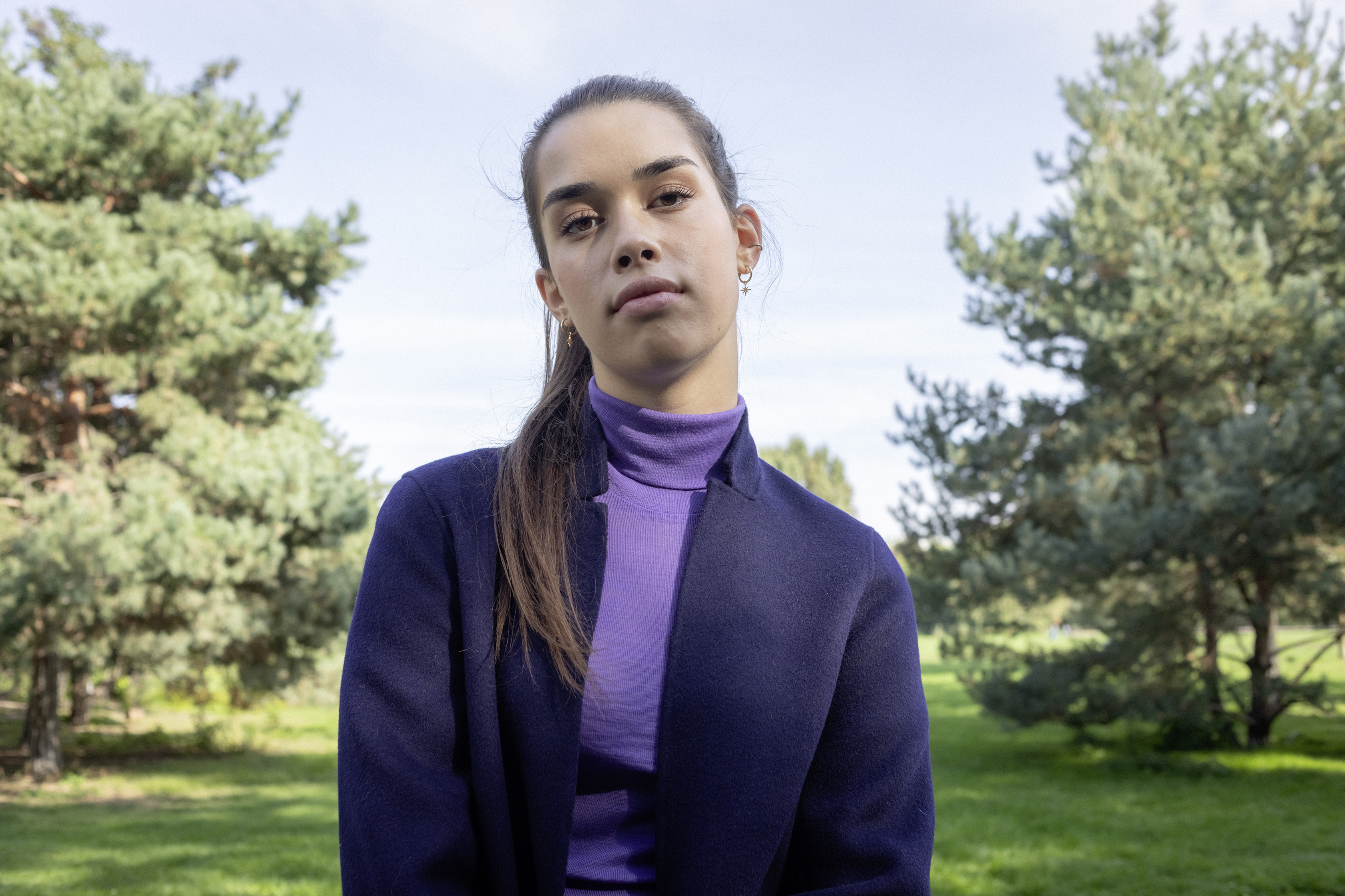 Eine Studentin steht im Park.