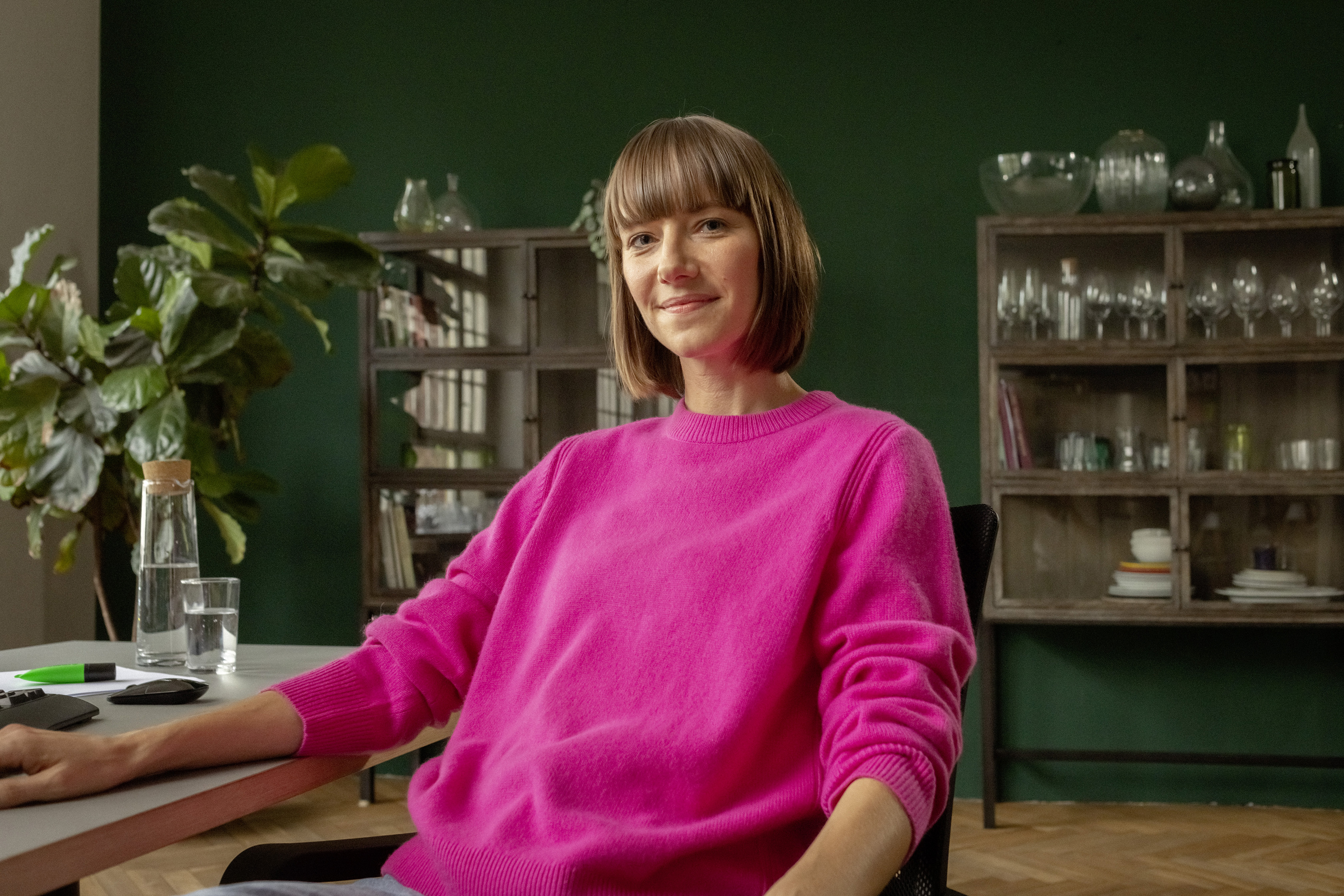 Eine berufserfahrene Frau sitzt am Schreibtisch in ihrer Wohnung.