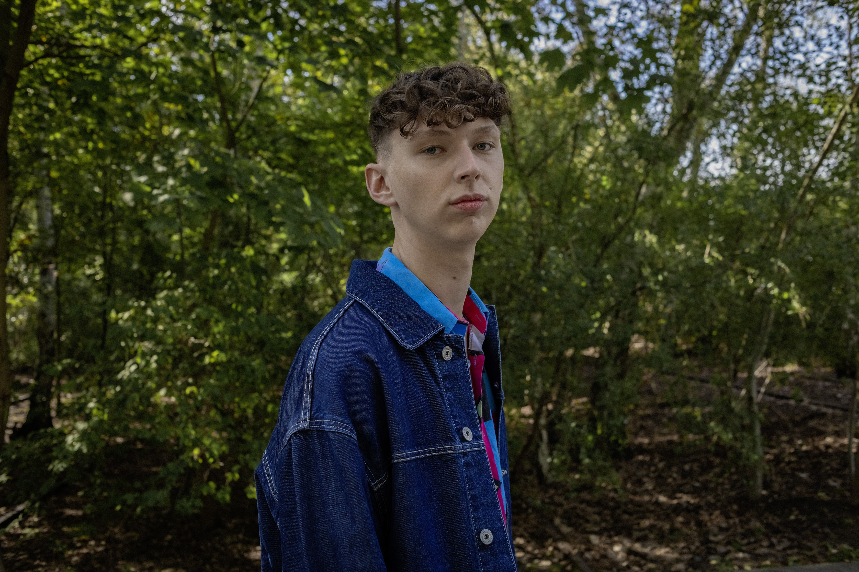 Ein Schüler steht im Park.