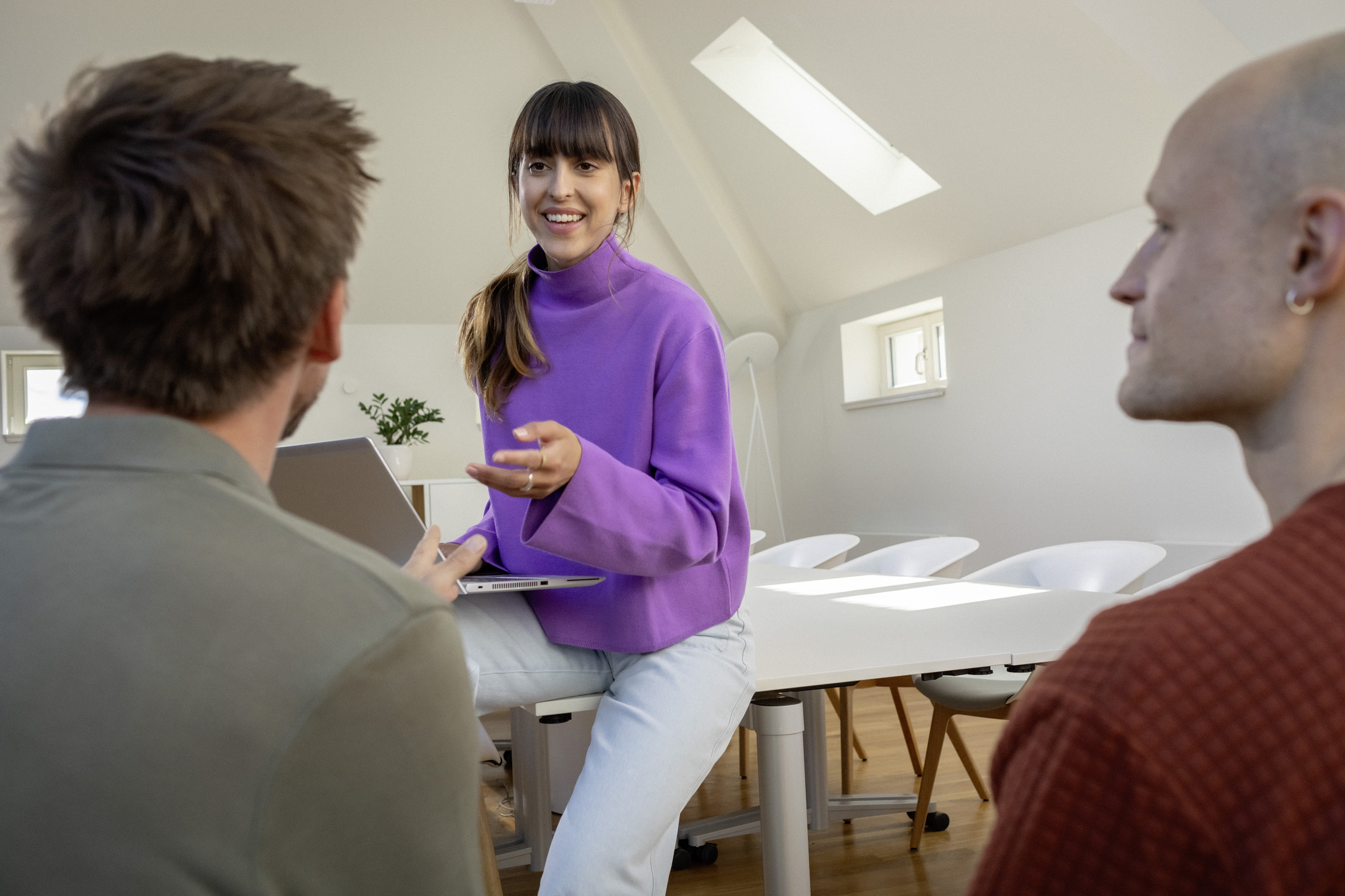 Berufserfahrene Mitarbeitende unterhalten sich an einem Besprechungstisch.