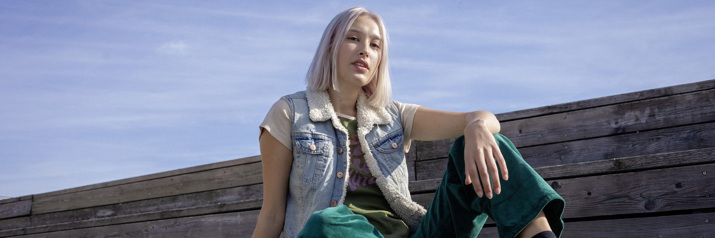 Eine Schülerin sitzt auf Holzstufen.