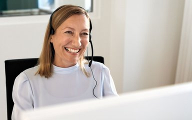 Eine AOK-Mitarbeiterin mit Headset nimmt Anrufe entgegen.