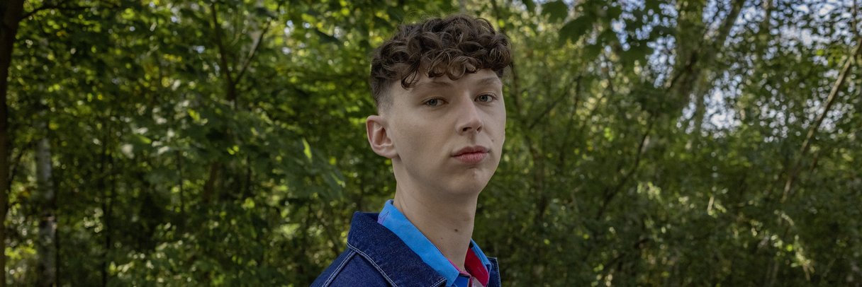 Ein Schüler steht im Park.