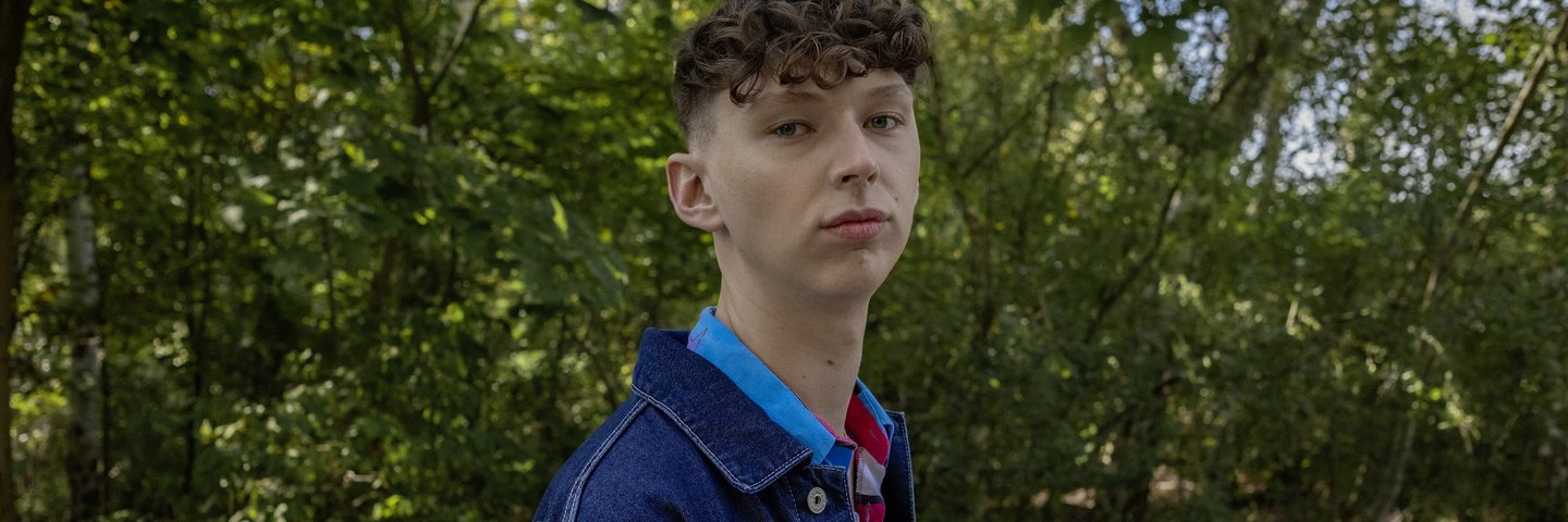 Ein Schüler steht im Park.