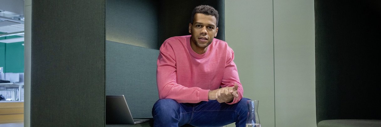 Ein junger Berufserfahrener macht eine Pause auf dem Sofa.