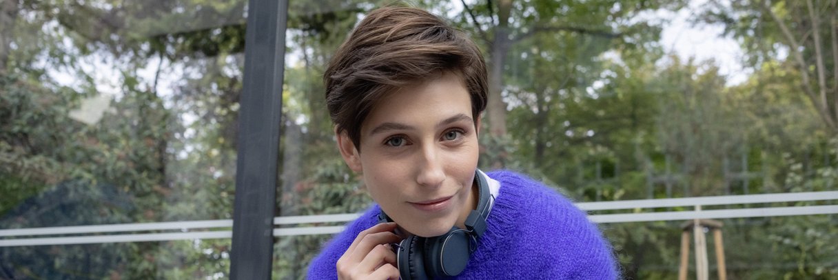 Eine Studentin sitzt in einer Bushaltestelle.