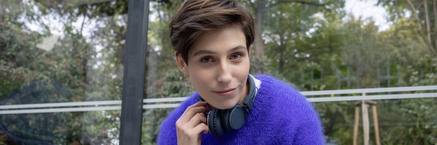 Eine Studentin sitzt in einer Bushaltestelle.