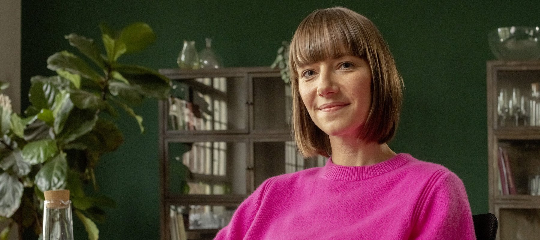 Eine berufserfahrene Frau sitzt am Schreibtisch in ihrer Wohnung.