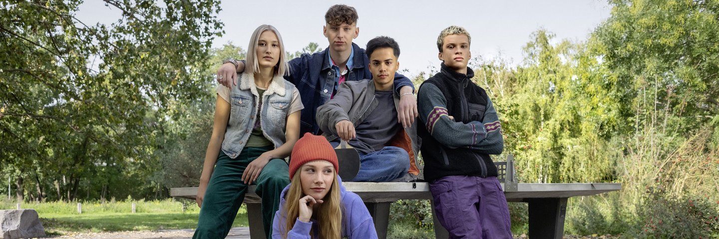 Eine Clique von Schülerinnen und Schülern posiert an einer Tischtennisplatte.