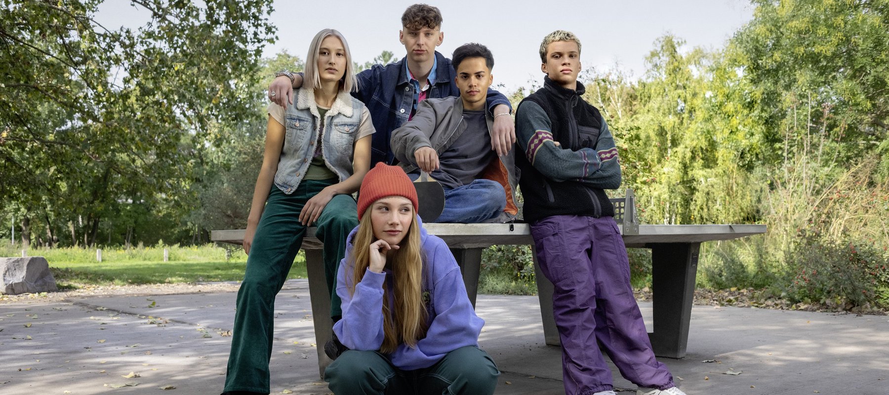 Eine Clique von Schülerinnen und Schülern posiert an einer Tischtennisplatte.