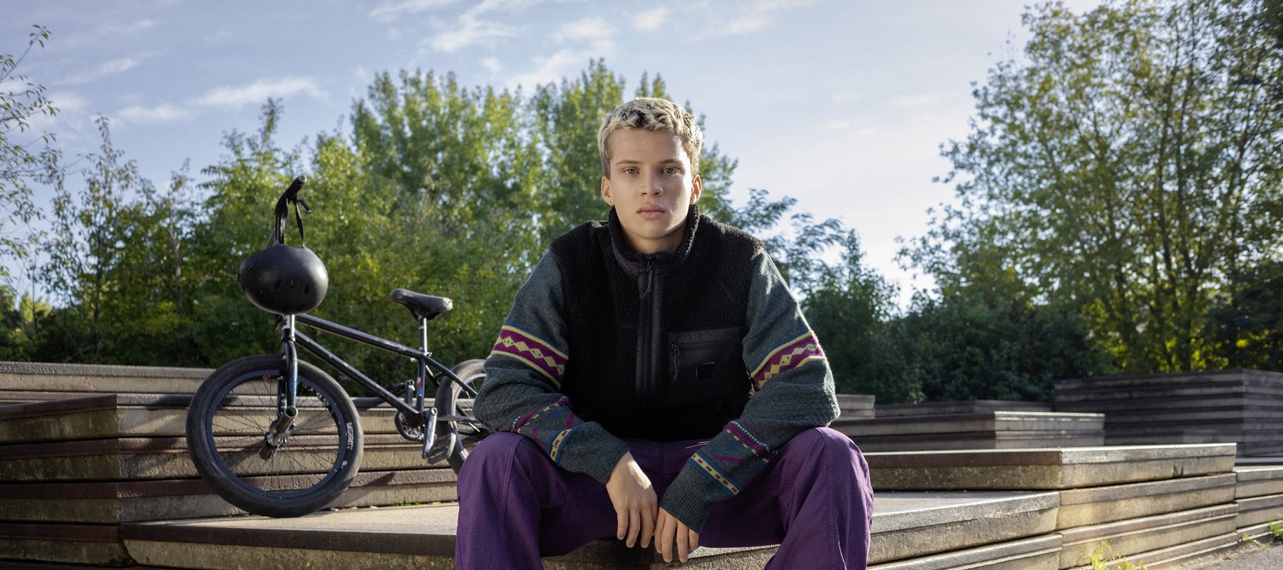 Ein Schüler sitzt im Park.