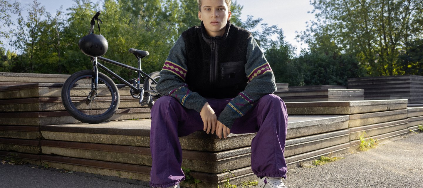 Ein Schüler sitzt im Park.