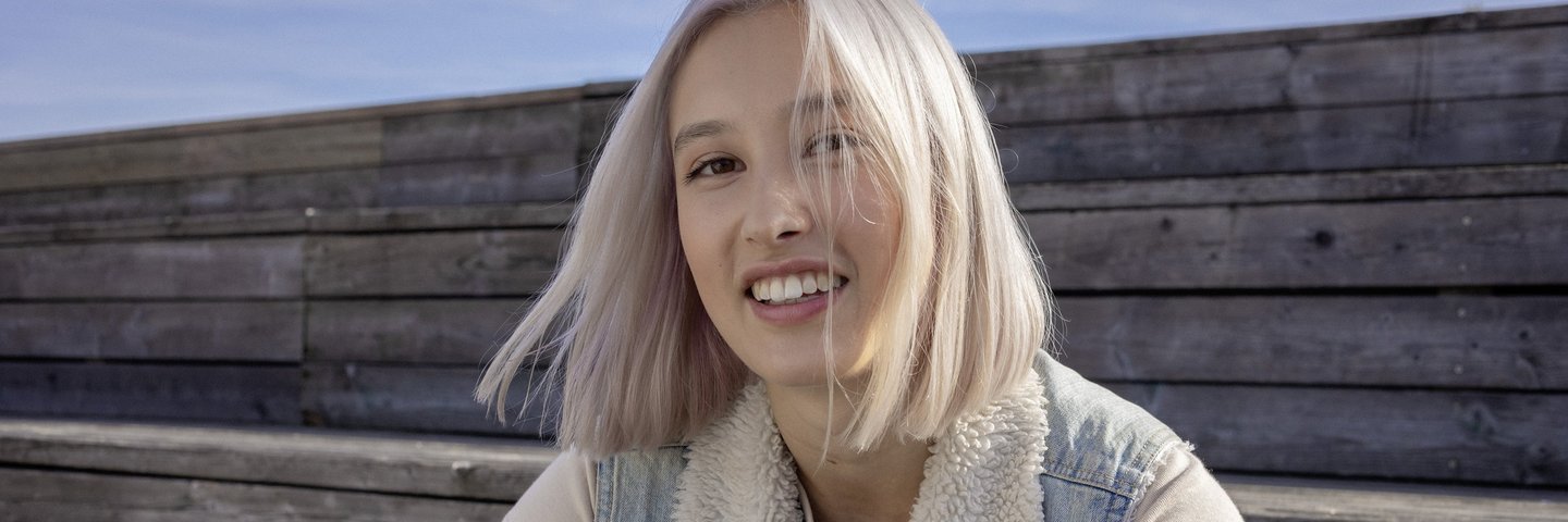 Eine Schülerin sitzt auf Holzstufen.